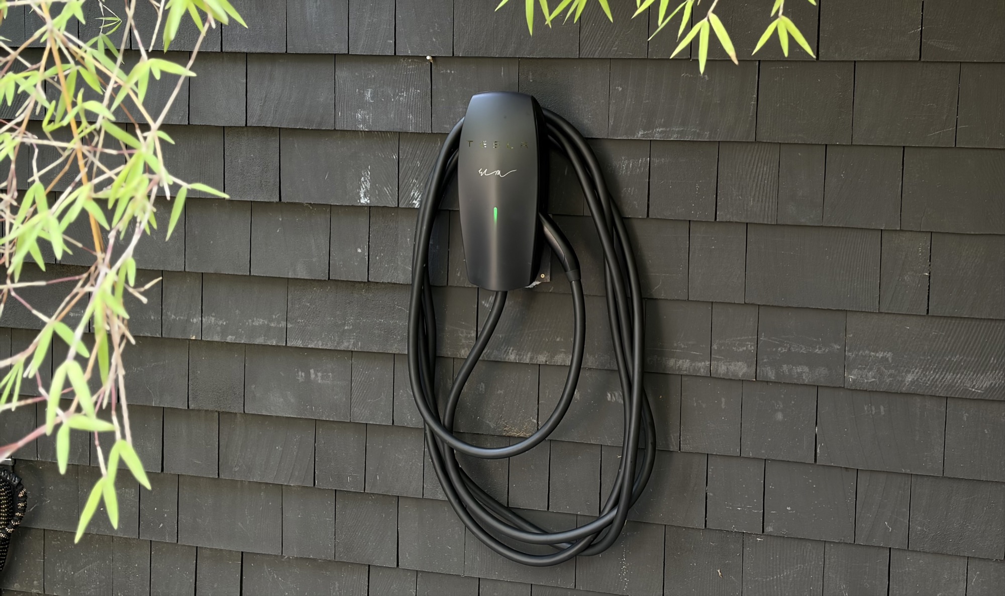 Limited-edition black Tesla Wall Connector installed with clean cable routing